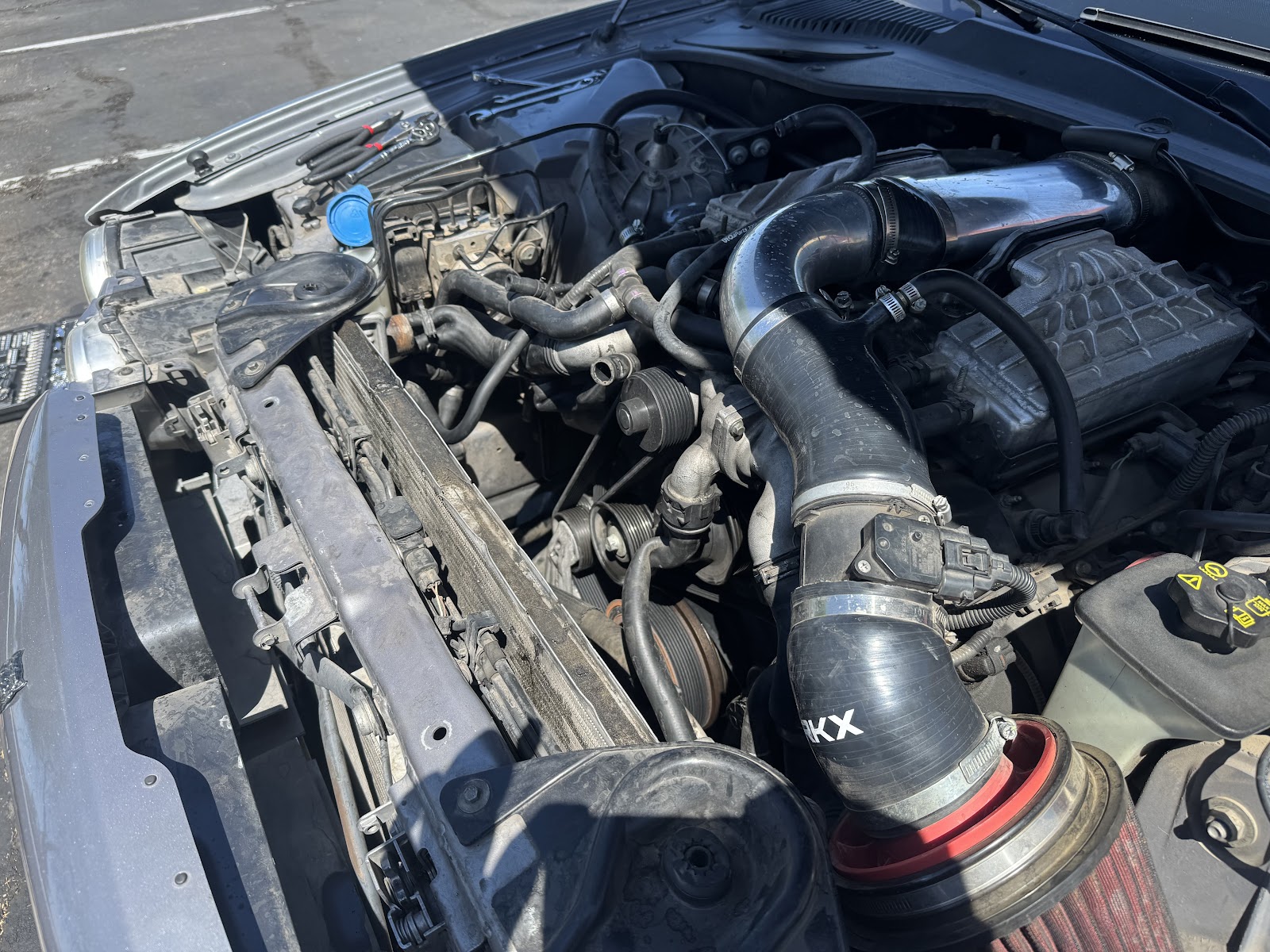 Pickup engine bay with a fresh cold air intake fitted and pliers lined up on the cowl